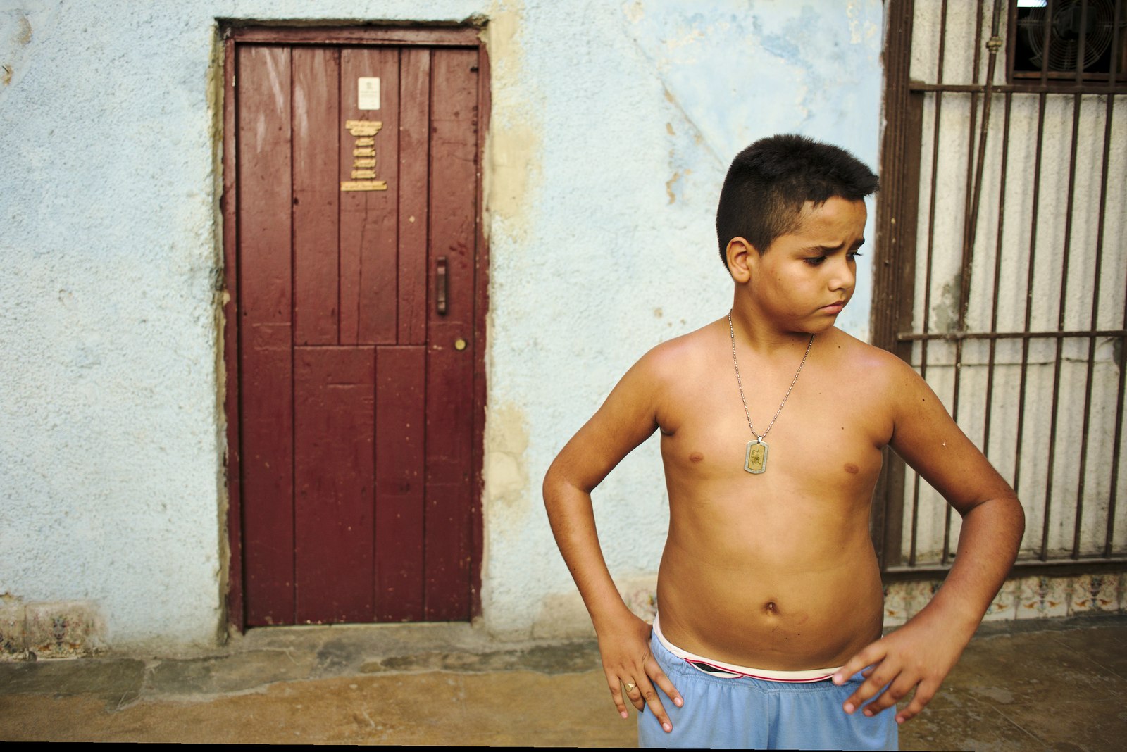 Rapaz numa pausa no jogo de futebol dentro de um pátio de uma casa antiga de Centro Habana.