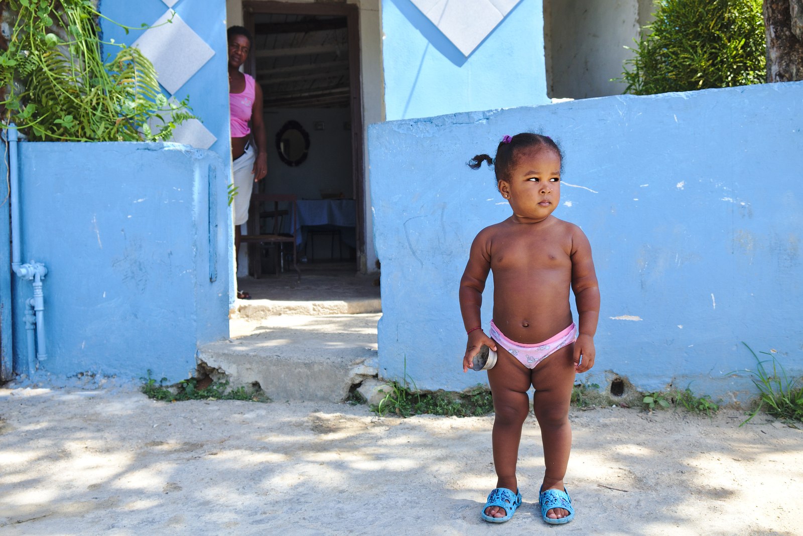 Menina confiadamente a sair da porta de casa.