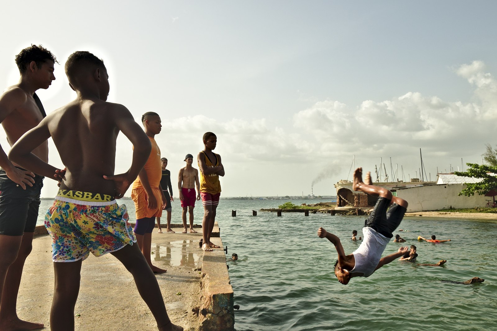 Boys using an abandoned pier close to Cienfuegos marina to dive on a hot Sunday.