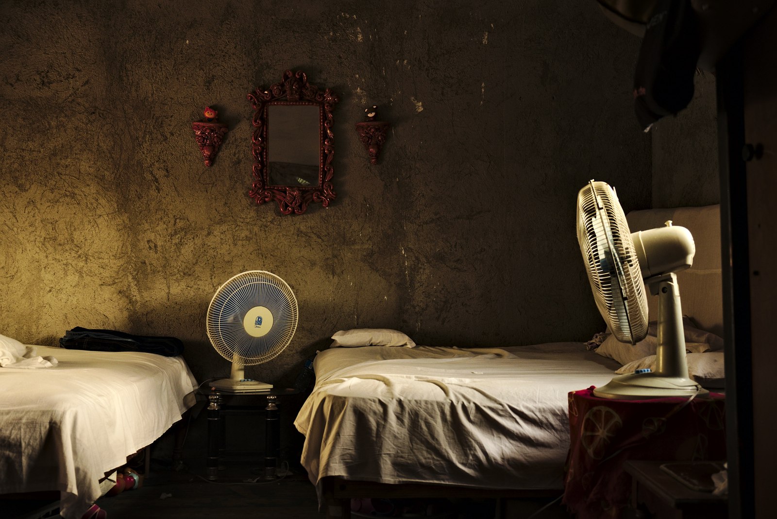 A room split between two men in Cienfuegos, the scorching heat of July explains those fans.