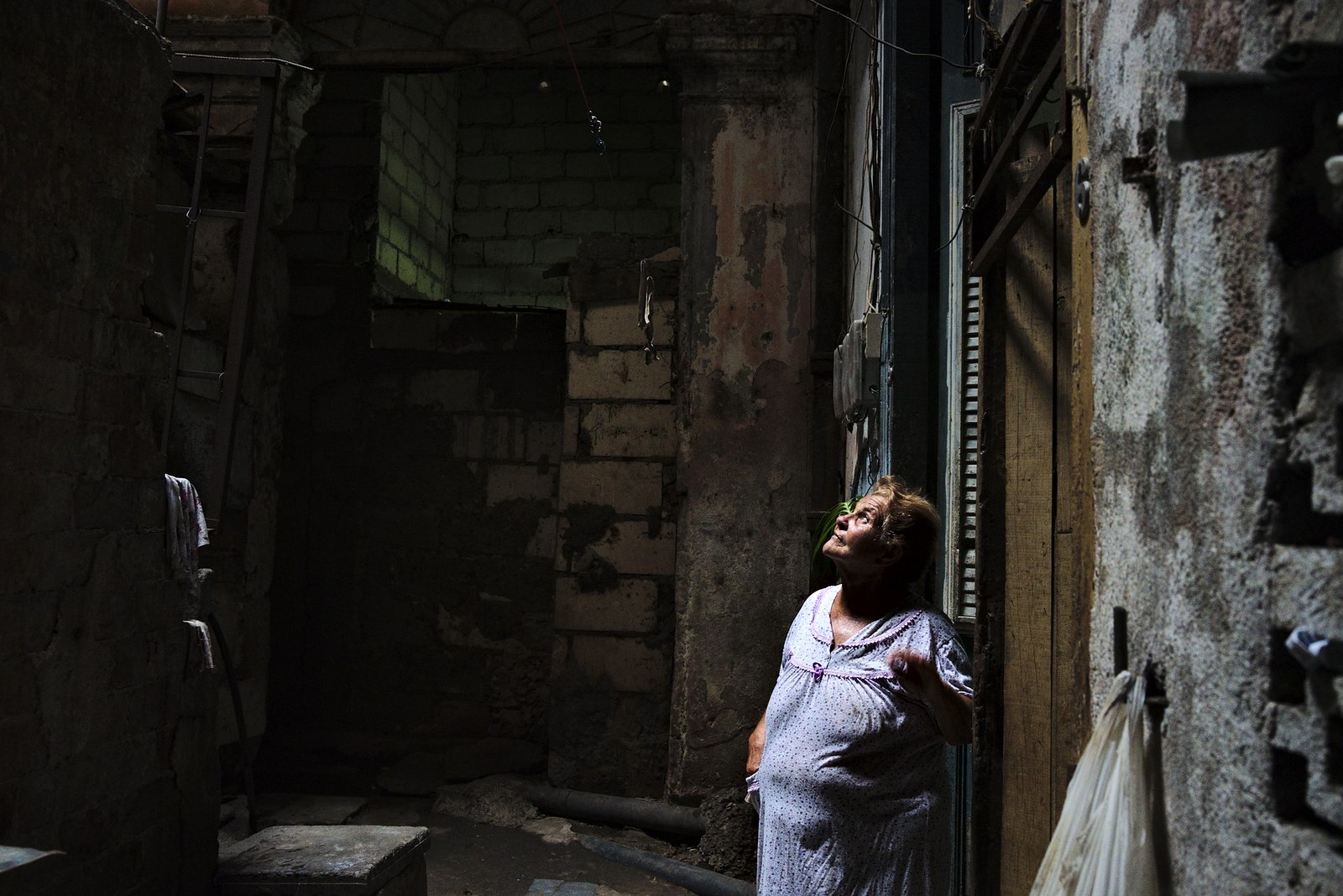 Woman outside her home on an abandoned hotel in Cienfuegos.