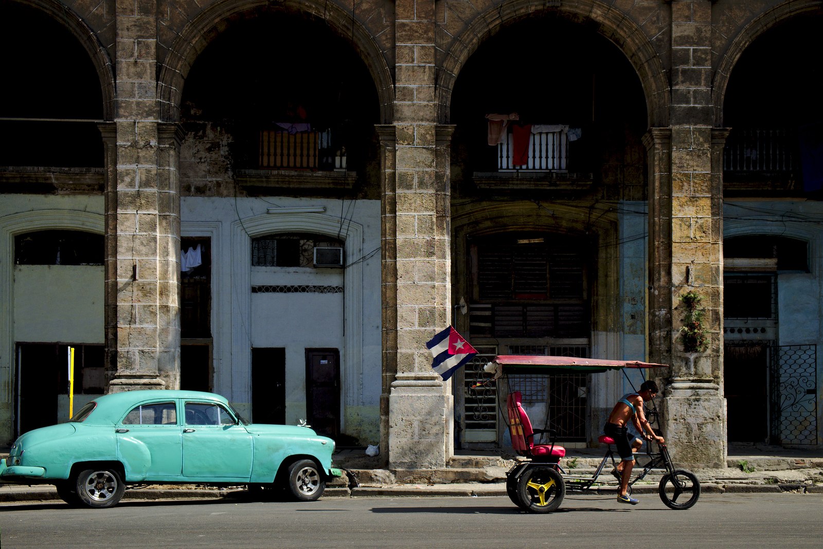 A classic American car parked outside the big arcades that are so typical of Centro Habana.